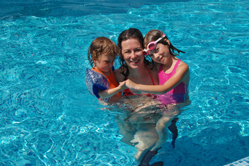 Mother with two kids in swimming pool