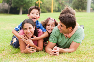 Fototapeta na wymiar Playful family lying outdoors and smiling