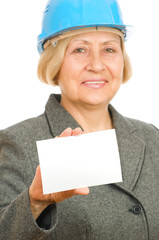 Senior woman with blue hard hat holding blank sigh