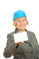 Senior woman with blue hard hat holding blank sigh