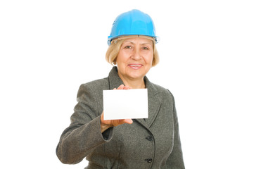 Senior woman with blue hard hat holding blank sigh
