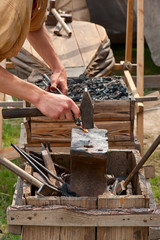 Ancient black smith craftsman working with steel
