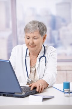Senior doctor using laptop computer