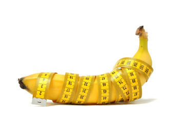 Banana and measure tape over white
