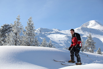 Naklejka na ściany i meble Jeune homme sur des skis à la neige
