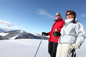 Homme et femme seniors regardant au loin à la neige