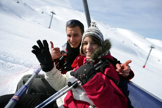 Couple assis sur un télésiège à la neige