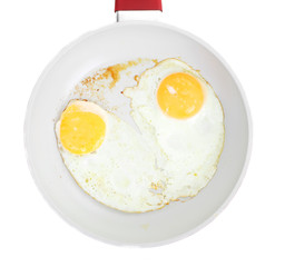 Broken egg frying in a pan isolated on white