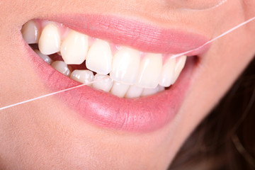 Frauenmund mit Zahnseide closeup