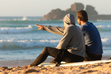 Two surfers talking on the beach