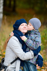 Boy kissing his mother outdoor