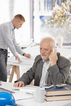 Senior businessman talking on landline phone