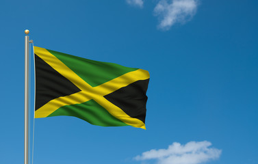 Flag of Jamaica waving in the wind in front of blue sky