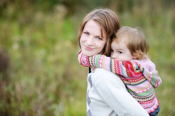 A girl having a piggyback ride on her mom