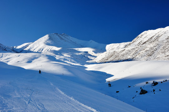 Winter in mountains with blue sky and skier