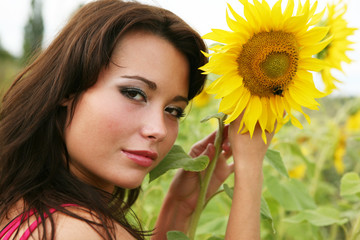 Naklejka premium The young woman with sunflowers.