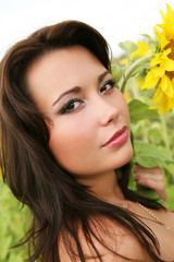 Naklejka premium The young woman with sunflowers.