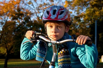 Fototapeta na wymiar Portrait of a boy on a bicycle in autumn park