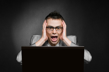 screaming businessman with laptop on black background