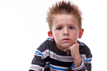 Cute young boy looking bored with his hand on his chin