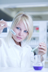 Closeup of a female researcher holding test tubes with chemicals