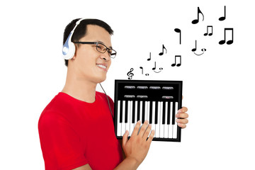 Young man holding a touch-pad pc and piano