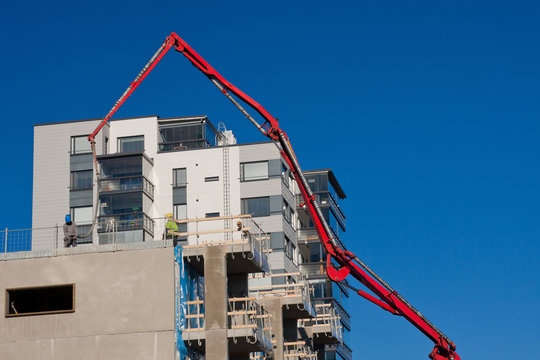 Huge Concrete Pump With Tall Arm Pumping Conrete On Top Of The B