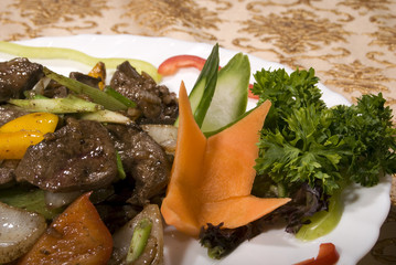 Fried juicy meat served with vegetables