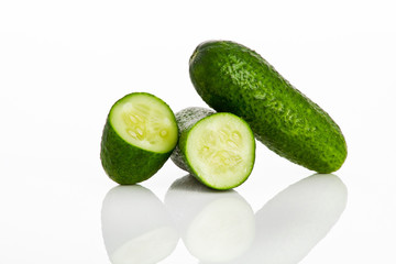 one and half cucumber isolated with reflection