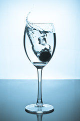 Splash of water and coins in a glass
