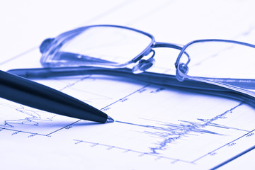 Pen and glasses on chart