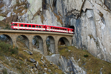 train on an old bridge going into a tunnel