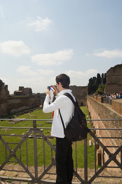 Joven turista fotografiando ruinas del palatino en Roma