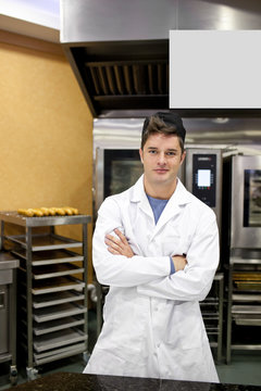 Proud baker standing in his kitchen waiting for baguettes