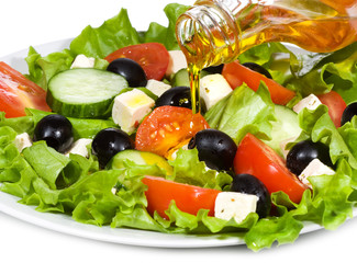 vegetable salad with  olive oil pouring from a bottle