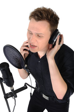 Young man singing to microphone on white background