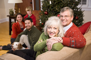 Senior couple with family by Christmas tree