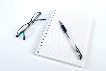 Pen,notebook and glasses on white background