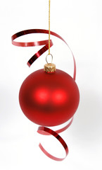 Hanging red glass ball with the ribbon on the white background