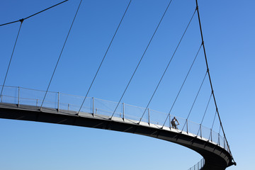 Naklejka premium cyclist crossing a bridge