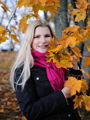 Beautiful autumn woman near yellow tree outdoors in forest