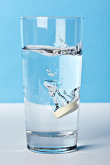 vitamin tablette fällt in wasserglas