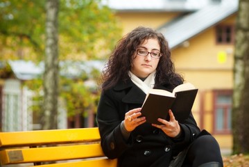 pretty woman sitting on bench in the yard