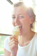 happy young woman is eating ice-cream in cafe