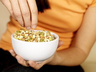 Young Woman Eating Mixed Seeds. Model Released