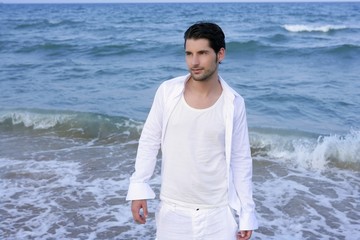 Latin young man white shirt walking blue beach