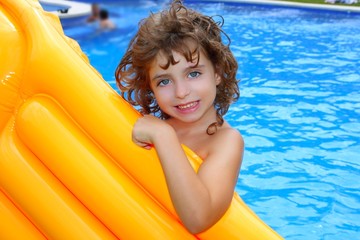 Beautiful little girl holding yellow pool float smiling