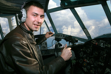 Young pilot in booth of the airplane