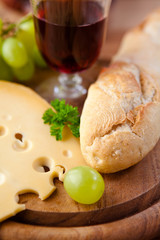 French hard cheese and baguette on kitchen board
