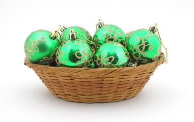 Several green Christmas ornaments in basket